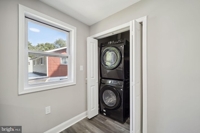 washroom with stacked washing maching and dryer and dark hardwood / wood-style flooring