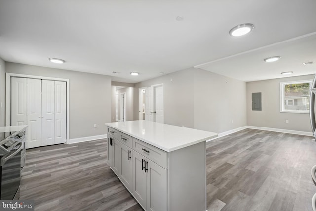 kitchen with a center island, light hardwood / wood-style floors, stainless steel electric stove, and electric panel