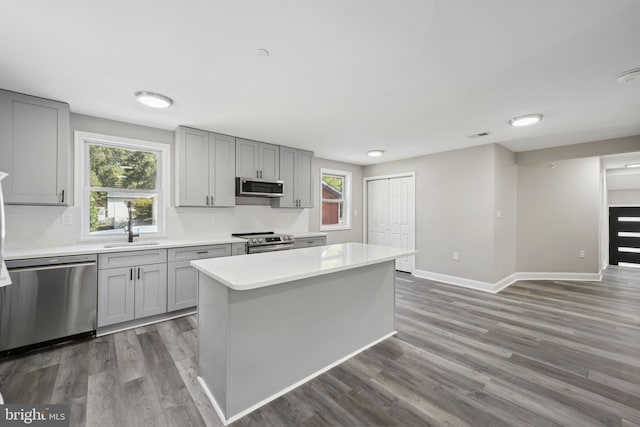 kitchen with stainless steel appliances, dark wood-type flooring, and a center island