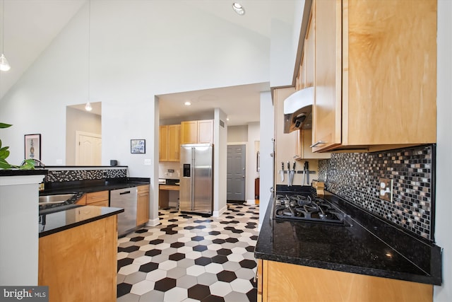 kitchen featuring decorative light fixtures, backsplash, high vaulted ceiling, stainless steel appliances, and dark stone counters