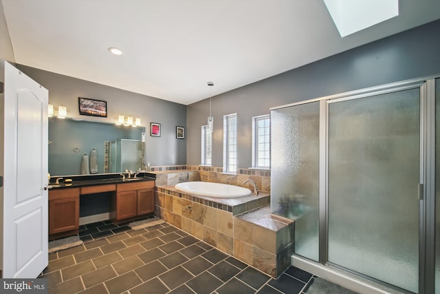 bathroom featuring independent shower and bath, a skylight, and vanity