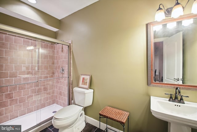 bathroom featuring tile patterned floors, sink, an enclosed shower, and toilet