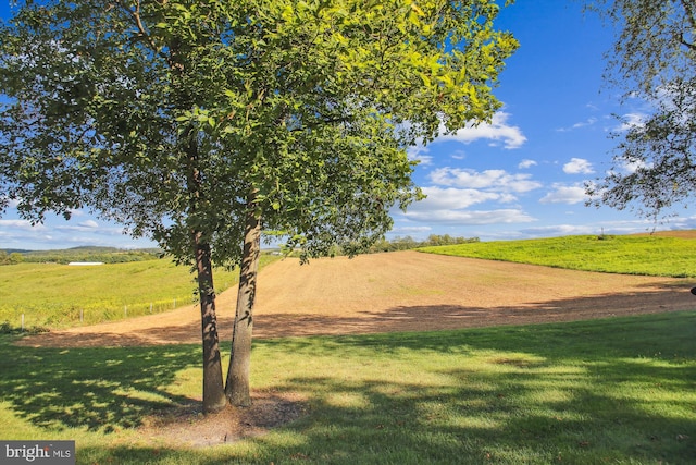 view of property's community featuring a rural view and a lawn