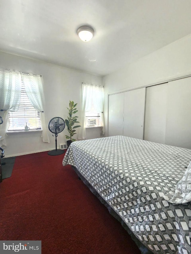 carpeted bedroom featuring cooling unit and a closet