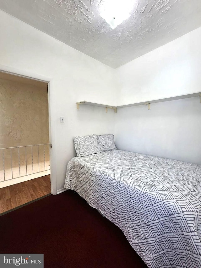 bedroom with a textured ceiling and hardwood / wood-style floors