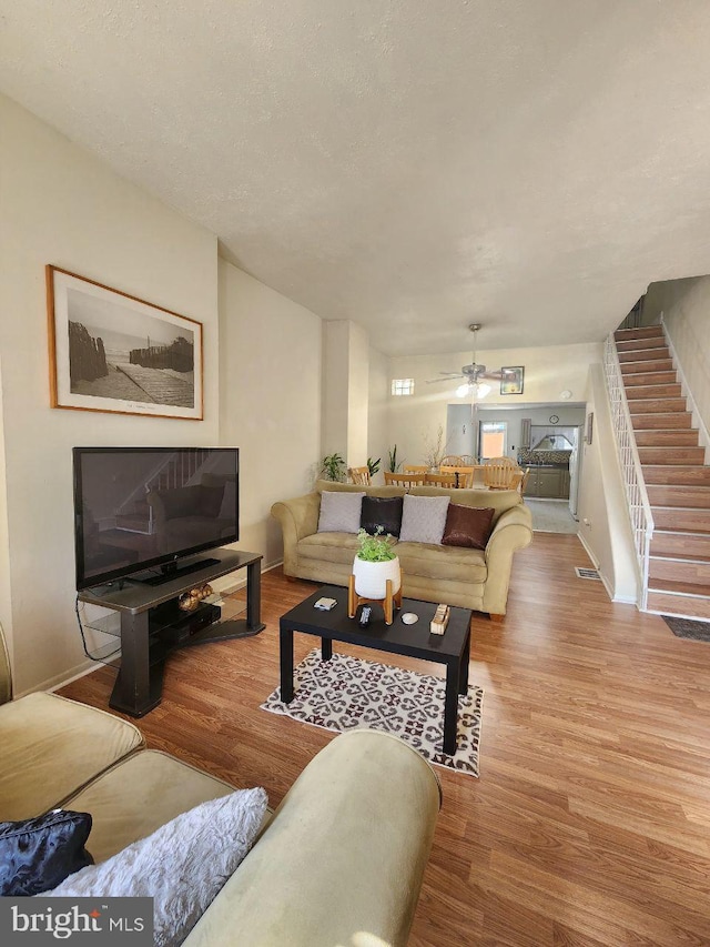 living room with light hardwood / wood-style flooring and ceiling fan