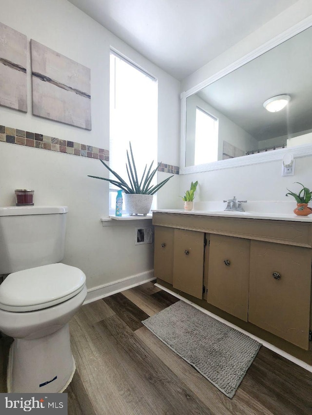 bathroom with hardwood / wood-style flooring, vanity, and toilet