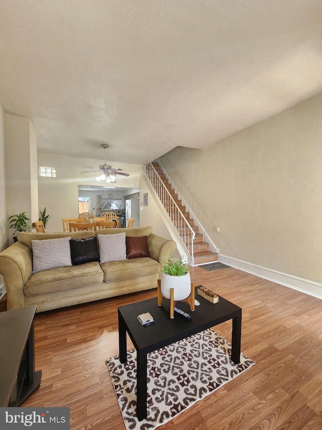 living room featuring hardwood / wood-style floors and ceiling fan