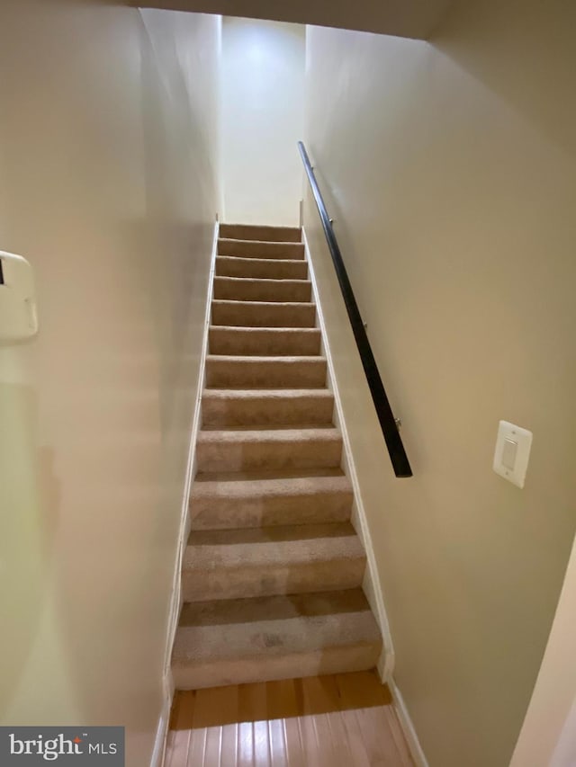 stairs featuring hardwood / wood-style floors