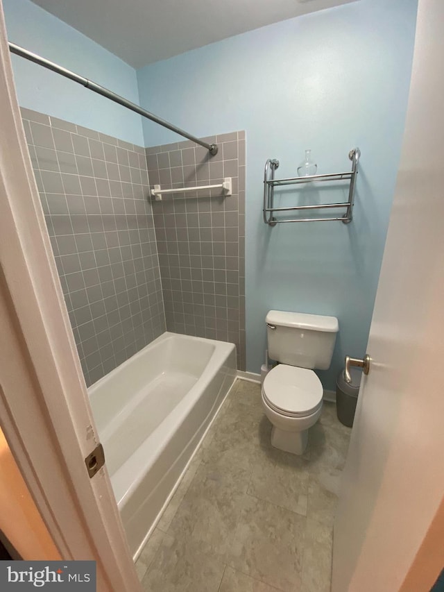 bathroom with toilet and tiled shower / bath combo