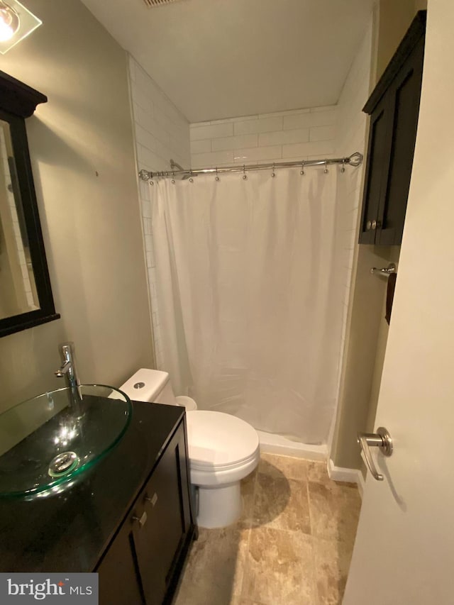 bathroom featuring walk in shower, vanity, and toilet