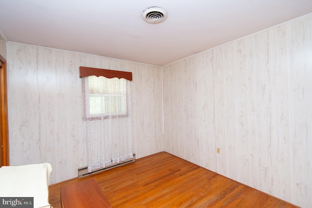 spare room featuring hardwood / wood-style flooring and a baseboard radiator