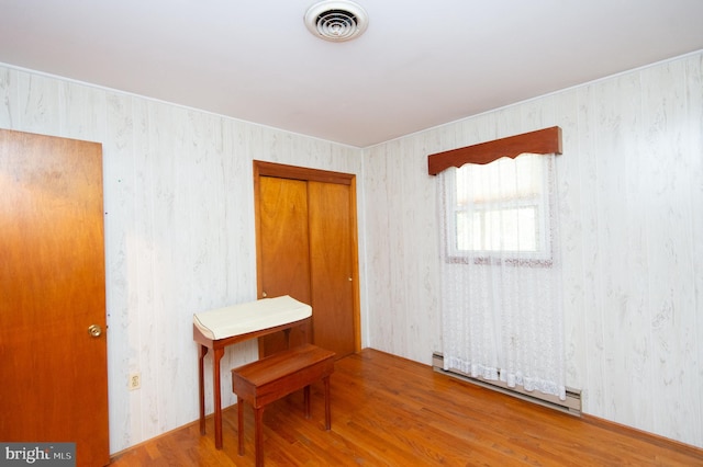 empty room with a baseboard radiator and hardwood / wood-style flooring