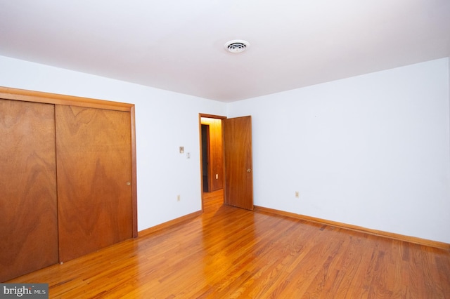 unfurnished bedroom with a closet and hardwood / wood-style floors