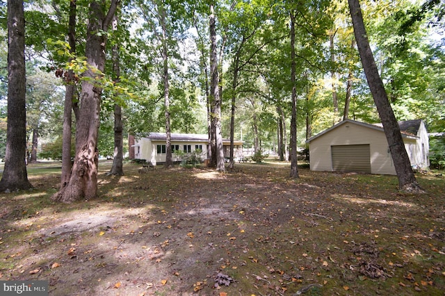 view of yard featuring an outdoor structure and a garage