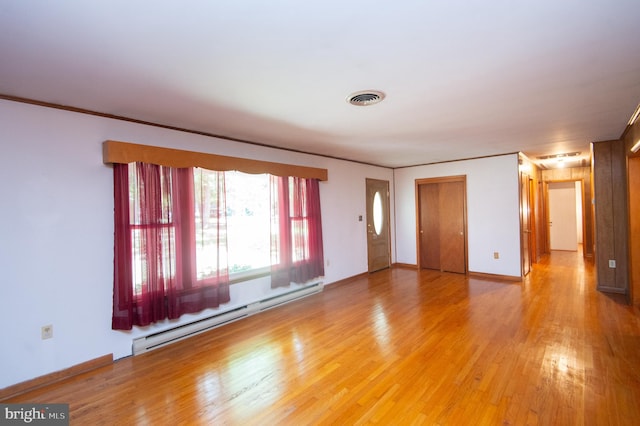 unfurnished room featuring a baseboard radiator, ornamental molding, and hardwood / wood-style floors