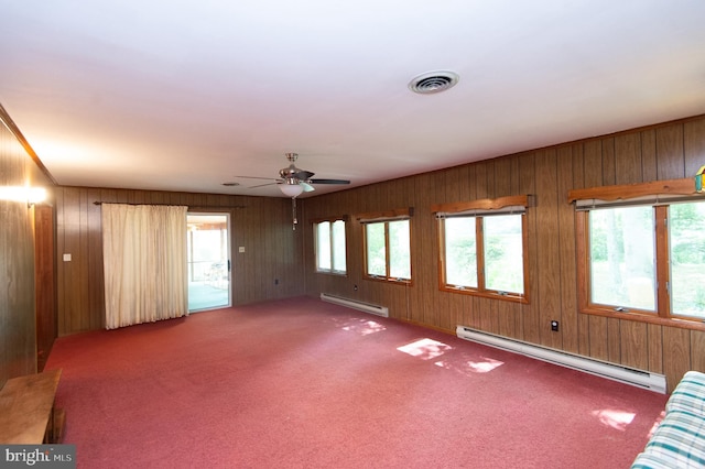 empty room featuring a baseboard heating unit, plenty of natural light, and ceiling fan