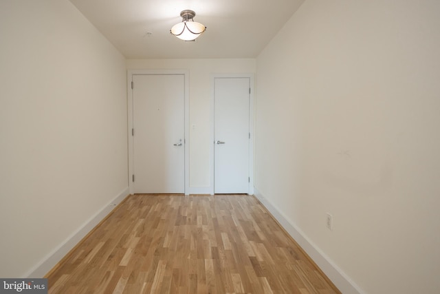 interior space with baseboards and light wood-style flooring