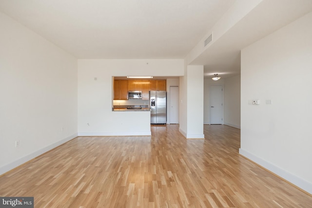 unfurnished living room featuring light wood-style flooring, baseboards, and visible vents