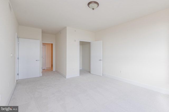 unfurnished bedroom with light carpet, visible vents, and baseboards