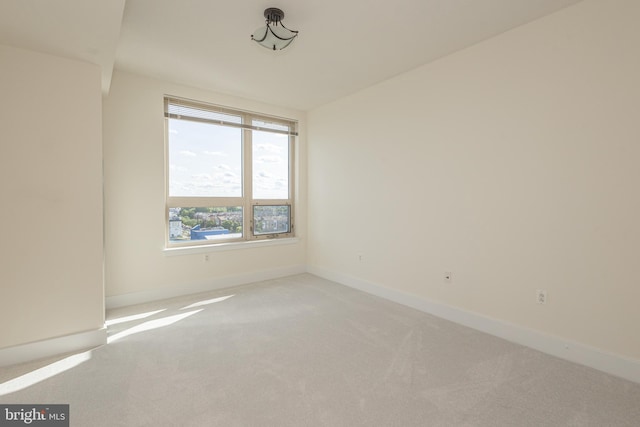 empty room with light colored carpet and baseboards