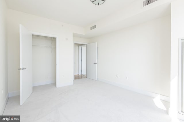 unfurnished bedroom featuring visible vents, light carpet, and baseboards