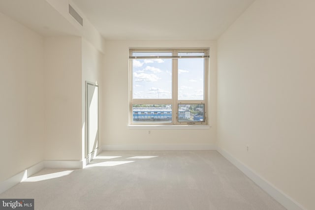 spare room featuring light carpet