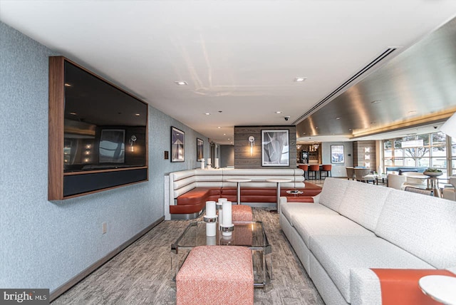 living area with recessed lighting, baseboards, a textured wall, and wood finished floors