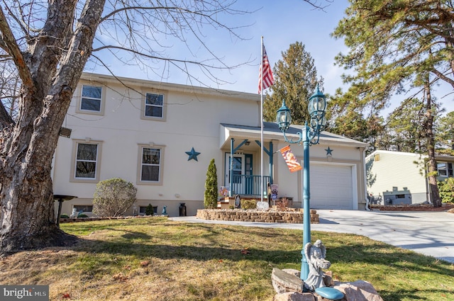 view of front of property with stucco siding, driveway, a front lawn, a porch, and an attached garage