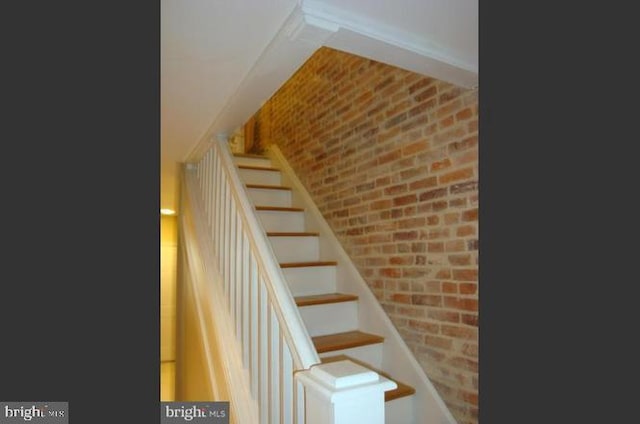 stairs featuring brick wall