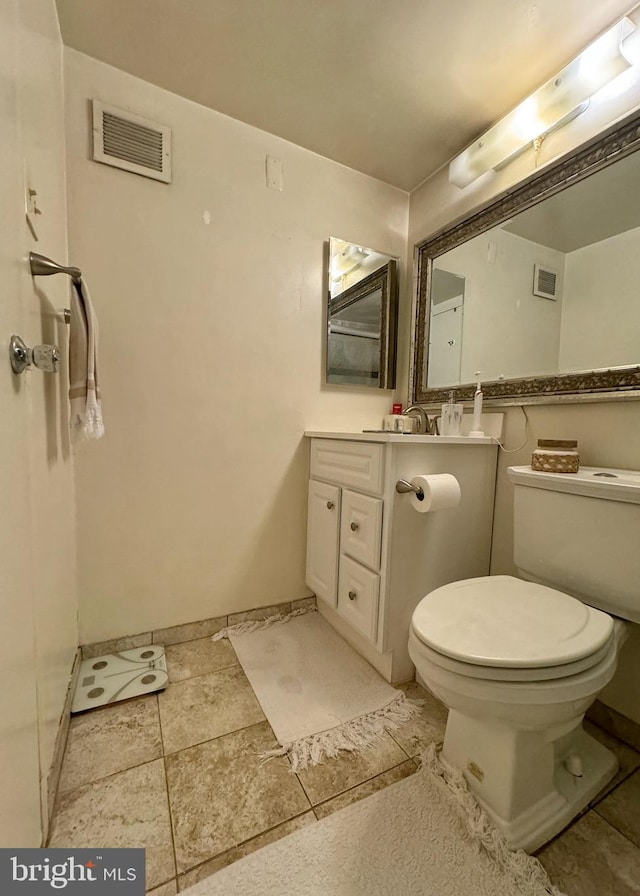 bathroom featuring tile patterned flooring, vanity, and toilet