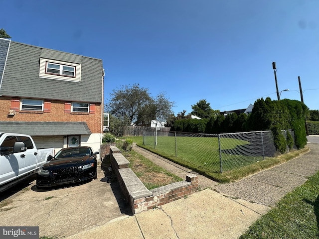 view of side of home featuring a lawn and a garage