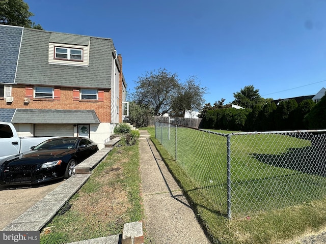 view of side of property featuring a lawn and a garage