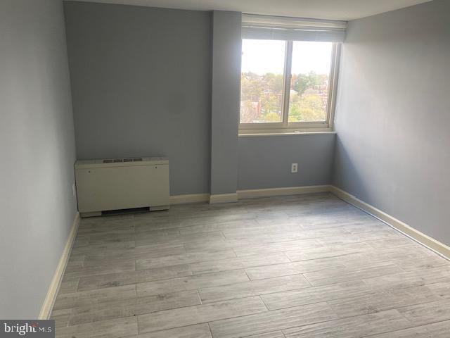 empty room featuring light hardwood / wood-style floors and radiator