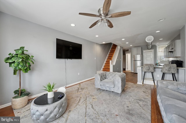 living room featuring ceiling fan and light wood-type flooring