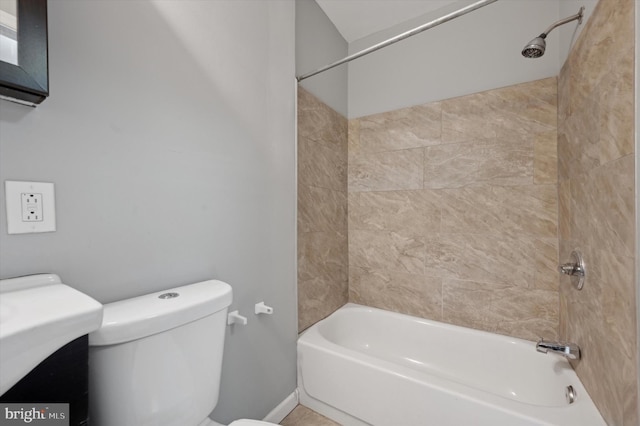 bathroom featuring toilet and tiled shower / bath combo