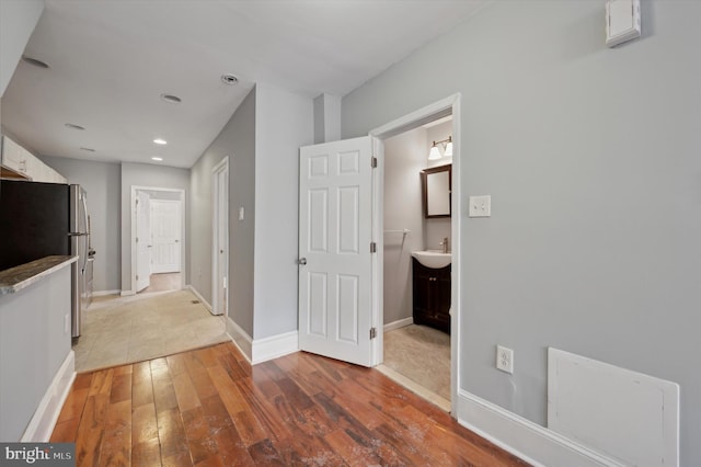 corridor with sink and wood-type flooring