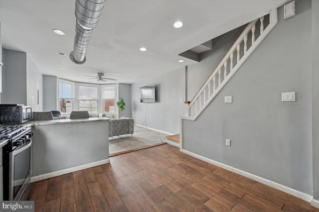 kitchen with hardwood / wood-style floors, stainless steel appliances, and ceiling fan