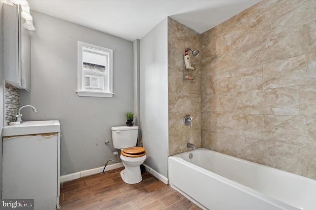 full bathroom featuring toilet, tiled shower / bath combo, and sink