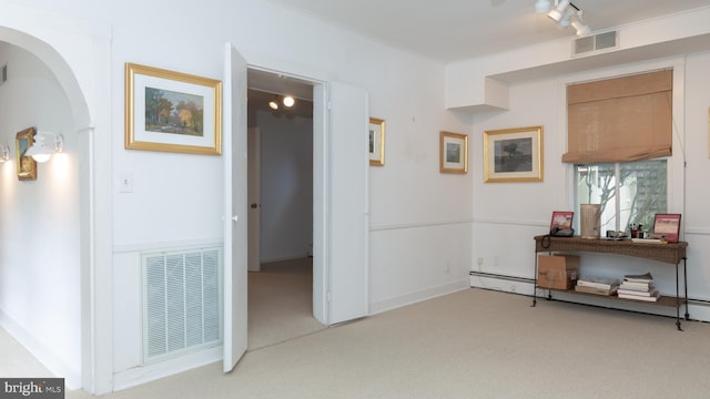 interior space with crown molding, light colored carpet, and track lighting