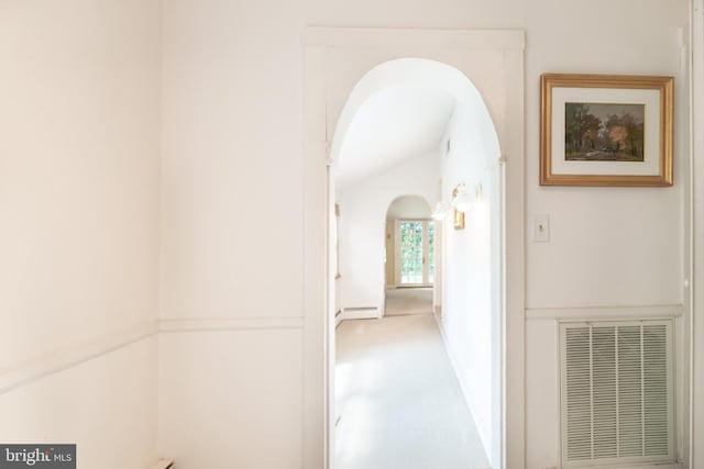 hallway with baseboard heating and vaulted ceiling