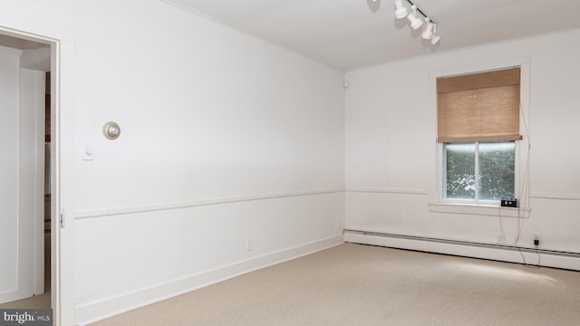 unfurnished room with track lighting, baseboard heating, crown molding, and carpet floors