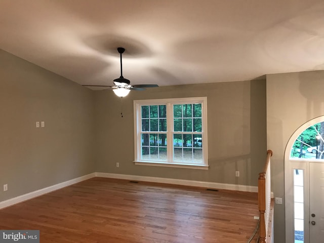 entrance foyer featuring ceiling fan, visible vents, baseboards, and wood finished floors