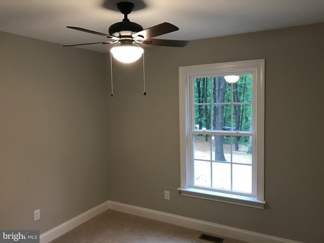 unfurnished room featuring a ceiling fan, baseboards, and visible vents