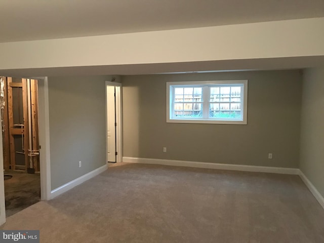 spare room featuring baseboards and carpet floors