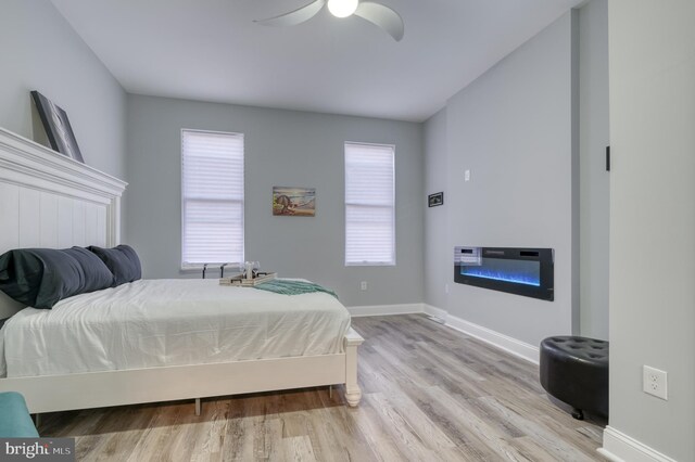 bedroom with light hardwood / wood-style floors and ceiling fan