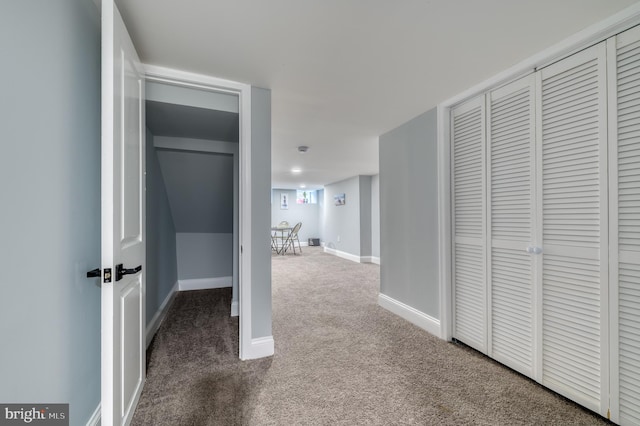 hall featuring dark colored carpet