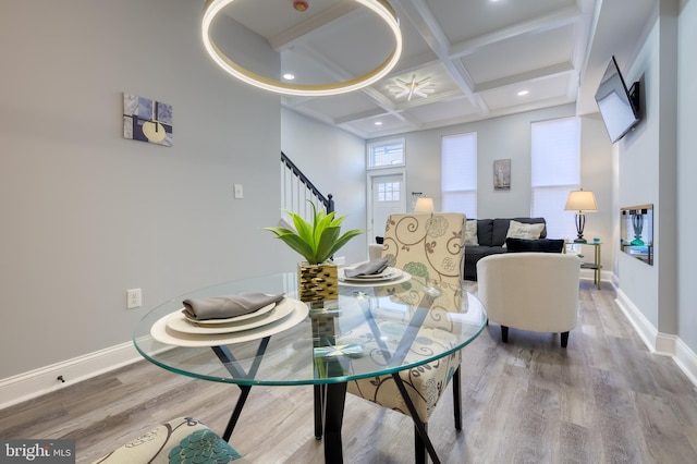 dining space with coffered ceiling, beamed ceiling, and hardwood / wood-style flooring