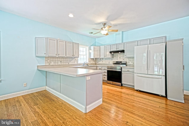 kitchen featuring white fridge, stainless steel electric stove, light hardwood / wood-style flooring, kitchen peninsula, and ceiling fan