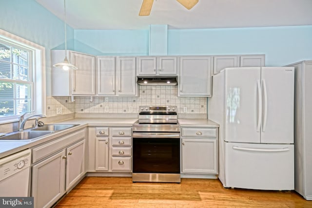 kitchen with white appliances, pendant lighting, light hardwood / wood-style flooring, sink, and ceiling fan